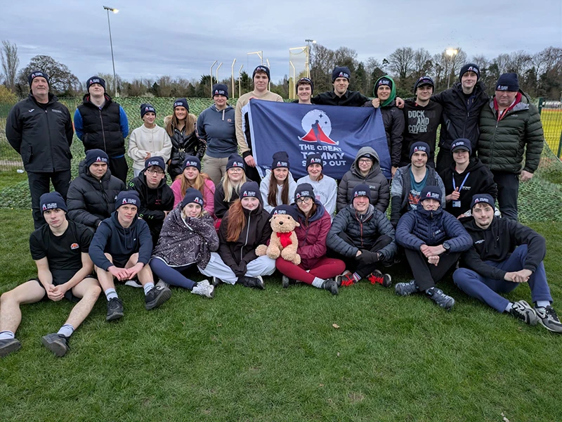 A large group of students holding a flag