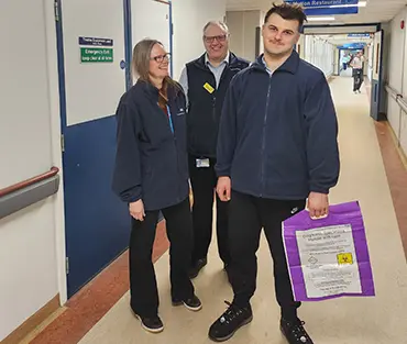 Two students and porter in hospital corridor 