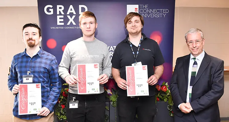 Three students holding certificates standing next to General Manager at Makita