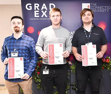 Three students holding certificates standing next to General Manager at Makita