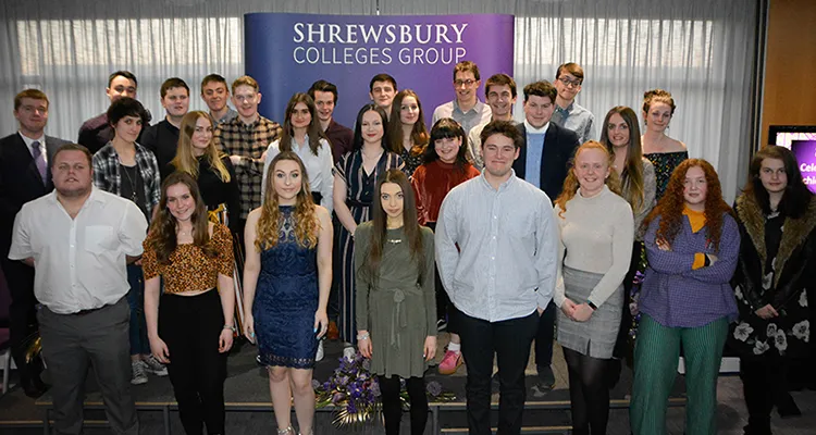 Large group of smartly dressed students standing in front of banner