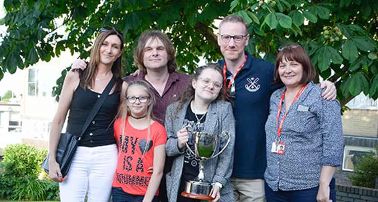 Staff and family members with arms around each other