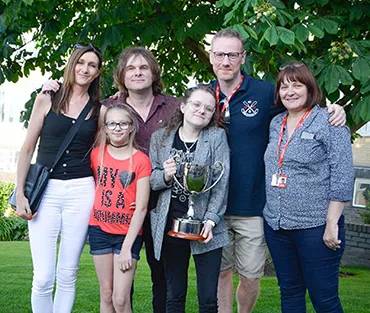 Staff and family members with arms around each other