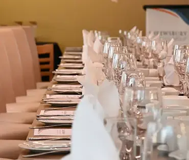 A row of glasses and place settings on a table