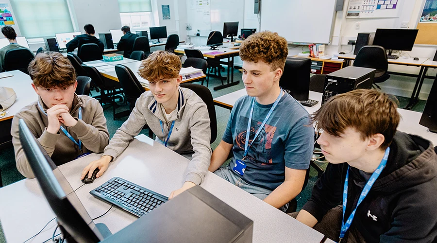 Four students looking at computer screen