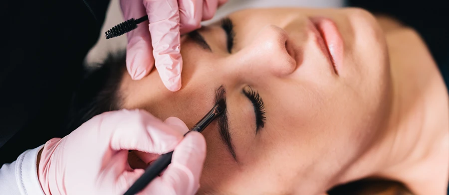 Student applying nail polish to client