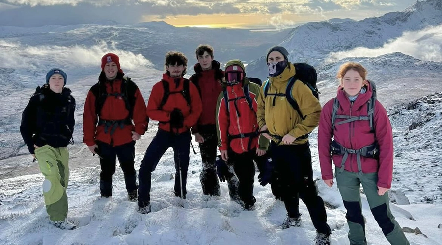 Students on snowy ground on a mountain top