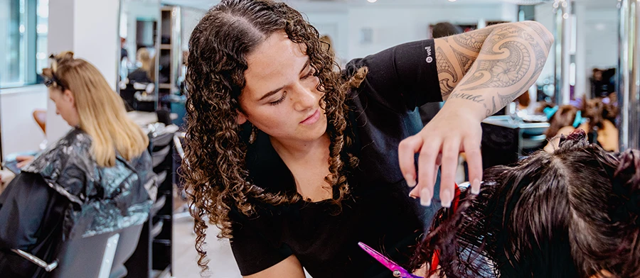 Student cutting customer's hair