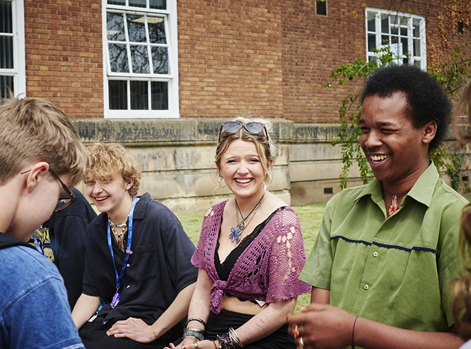 young students sitting at a bench outside