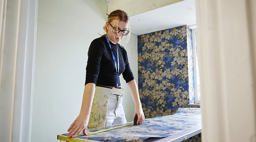 Student measuring wallpaper