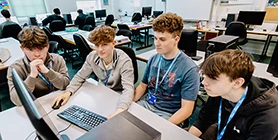 Four students looking at a computer screen